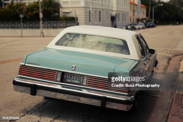 a classic vintage turquoise ford mercury grand marquis parked in residential area in miami beach, florida - mercury transit stock-fotos und bilder