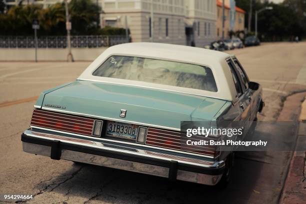 a classic vintage turquoise ford mercury grand marquis parked in residential area in miami beach, florida - mercury transit stock pictures, royalty-free photos & images