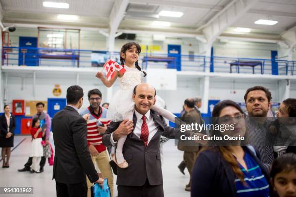 Hadi Elhami, originally from Iran, carries his daughter, Arnika Elhami, on his shoulder during a citizenship ceremony held at the Royal Canadian Navy...