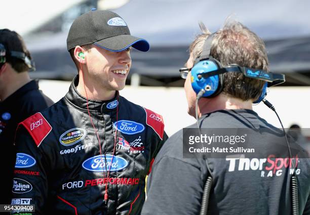 Ben Rhodes, driver of the Alpha Energy Solutions Ford, stands by his truck during practice for the NASCAR Camping World Truck Series JEGS 200 at...
