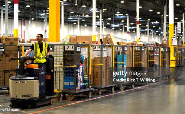 Worker drives a Powered Industrial Truck at the Amazon fullfillment center May 3, 2018 in Aurora, Colorado. The million square foot facility,...