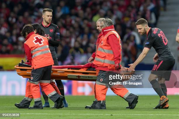Laurent Koscielny of Arsenal receives medical help and Shkodran Mustafi of Arsenal looks on during the UEFA Europa League Semi Final second leg match...
