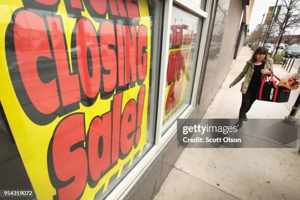 Signs in the window of a Sears store advertise the store's closing on May 3, 2018 in Chicago, Illinois. The store, which opened in 1938, is the...