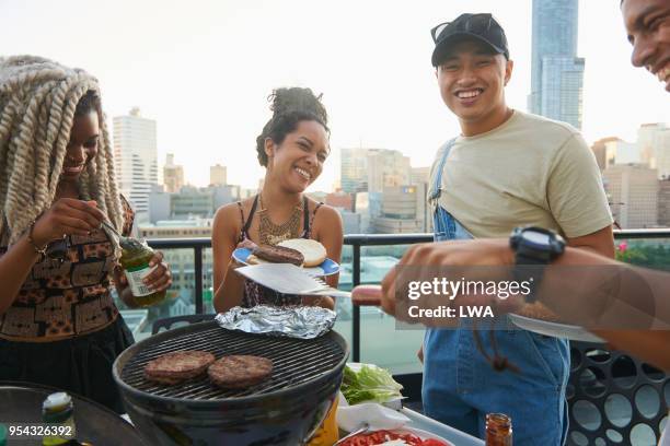 group of friends having a rooftop get together - asian person bbq stock-fotos und bilder