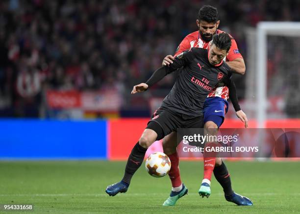 Arsenal's German midfielder Mesut Ozil vies with Atletico Madrid's Spanish forward Diego Costa during the UEFA Europa League semi-final second leg...