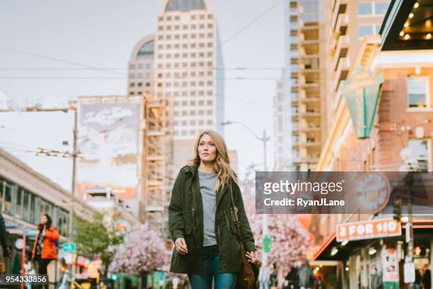 a confident woman walks around downtown seattle - seattle stock pictures, royalty-free photos & images