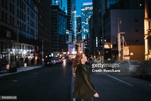 portrait of woman walking downtown seattle at night - seattle city life stock pictures, royalty-free photos & images