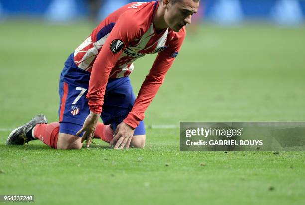 Atletico Madrid's French forward Antoine Griezmann kneels on the field during the UEFA Europa League semi-final second leg football match between...