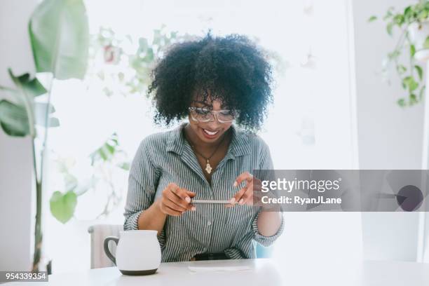 a young woman does remote deposit capture of check - portable information device stock pictures, royalty-free photos & images