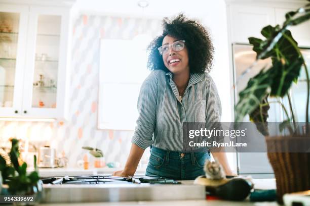 a young woman relaxes in her modern home kitchen - seattle houses stock pictures, royalty-free photos & images