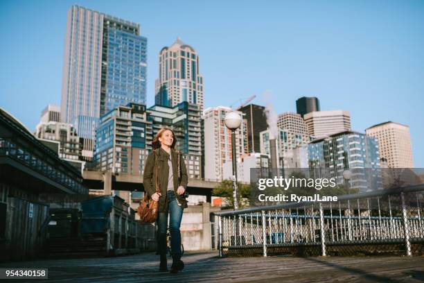 mujer de negocios informal toma un descanso por seattle waterfront - seattle fotografías e imágenes de stock