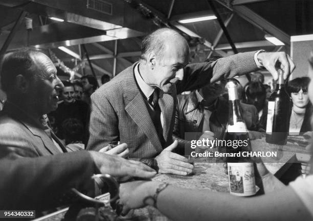 Valéry Giscard d'Estaing au comptoir d'un bar entouré de consommateurs en juin 1981 en France.