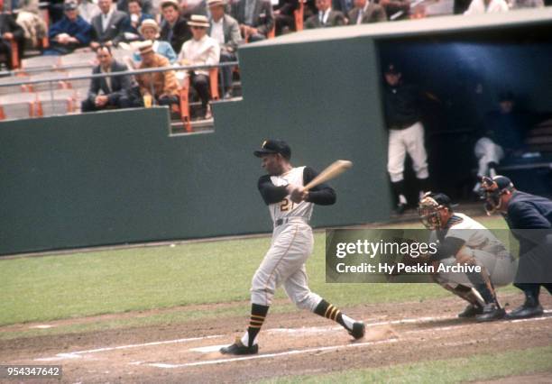 Roberto Clemente of the Pittsburgh Pirates swings at the pitch as catcher Ed Bailey of the San Francisco Giants and umpire Paul Pryor look on during...