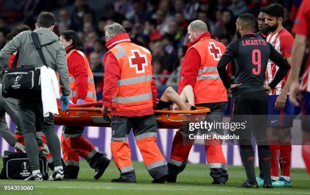 Medical staff carry Laurent Koscielny of Arsenal after he was injured during the UEFA Europa League semi final return match between Atletico Madrid...