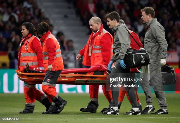 Medical staff carry Laurent Koscielny of Arsenal after he was injured during the UEFA Europa League semi final return match between Atletico Madrid...