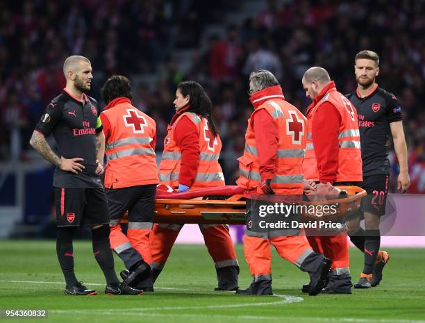 Laurent Koscielny of Arsenal is stretchered from the pitch during the UEFA Europa League Semi Final second leg match between Atletico Madrid and...