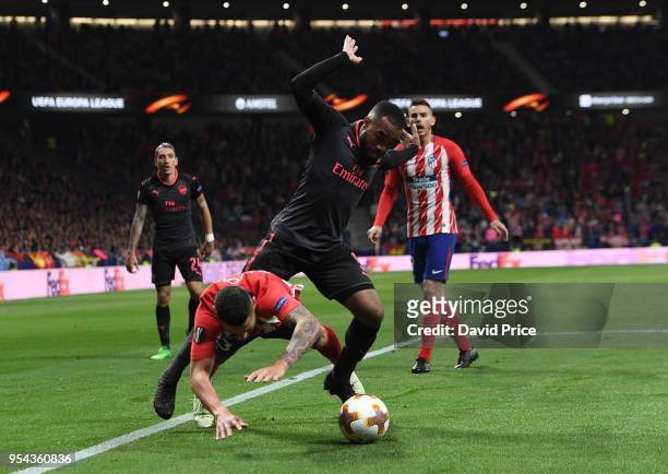 Alexandre Lacazette of Arsenal challenges Vitolo of Atletico during the UEFA Europa League Semi Final second leg match between Atletico Madrid and...