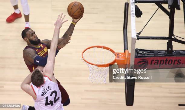 Toronto Raptors center Jakob Poeltl defends against Cleveland Cavaliers forward LeBron James as the Toronto Raptors play the Cleveland Cavaliers in...