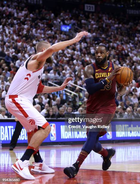 LeBron James of the Cleveland Cavaliers dribbles the ball as Jonas Valanciunas of the Toronto Raptors defends in the second half of Game One of the...