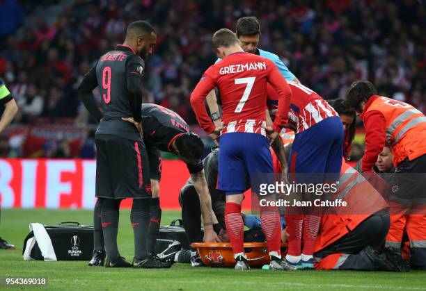 Alexandre Lacazette, Granit Xhaka of Arsenal, Antoine Griezmann of Atletico Madrid worries for Laurent Koscielny of Arsenal liyng on a stretcher...