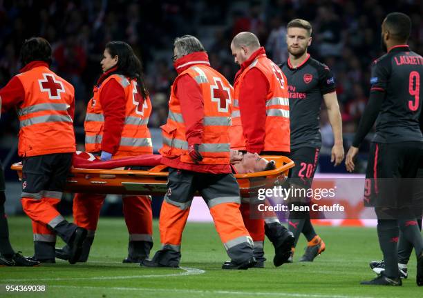 Injured, Laurent Koscielny of Arsenal leaves the pitch on a stretcher during the UEFA Europa League Semi Final second leg match between Atletico...