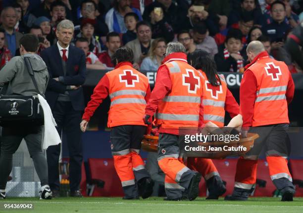 Injured, Laurent Koscielny of Arsenal leaves the pitch on a stretcher in front of coach of Arsenal Arsene Wenger during the UEFA Europa League Semi...