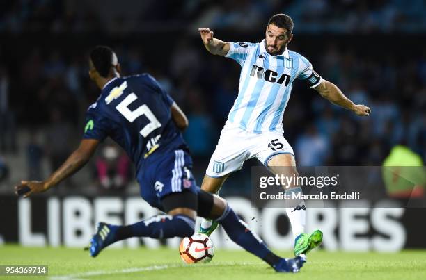 Lisandro Lopez of Racing Club kicks the ball against Rafael Vaz of Universidad de Chile during a group stage match between Racing Club and...