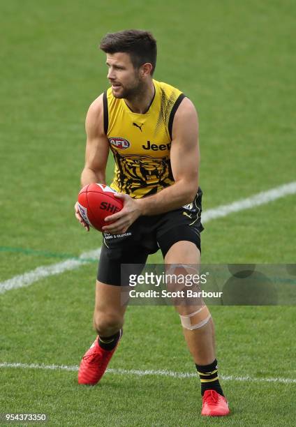 Trent Cotchin of the Tigers runs with the ball with a taped knee during the Richmond Tigers AFL training session on May 4, 2018 in Melbourne,...