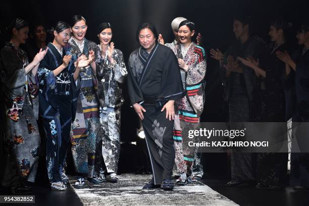 This picture taken on March 21, 2018 shows kimono designer Jotaro Saito greeting the audience at the end of his 2018 autumn/winter collection at...