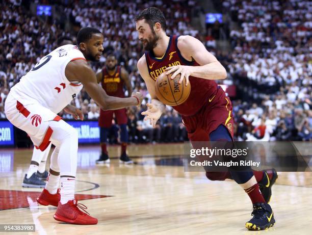 Kevin Love of the Cleveland Cavaliers dribbles the ball as C.J. Miles of the Toronto Raptors defends in the second half of Game Two of the Eastern...