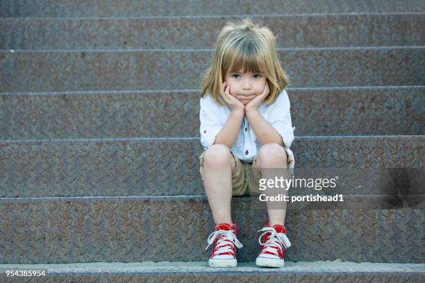 muchacho triste sentado en la escalera - toddler boy fotografías e imágenes de stock