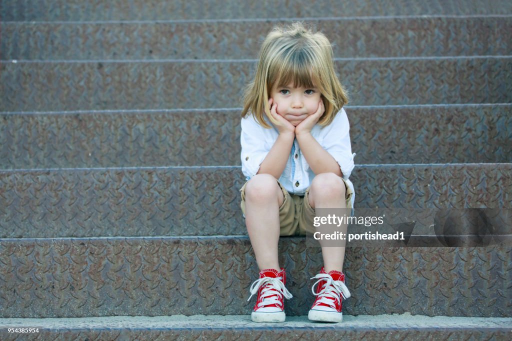 Sad boy sitting on staircase