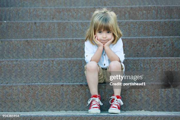 sad boy sitting on staircase - sad children only stock pictures, royalty-free photos & images