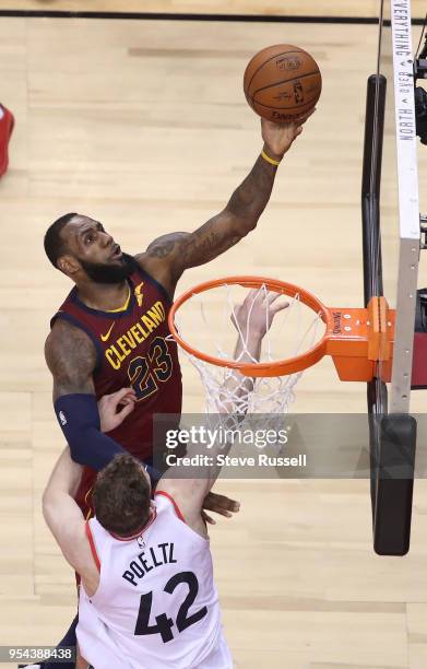 Cleveland Cavaliers forward LeBron James lays in a shot over Toronto Raptors center Jakob Poeltl as the Toronto Raptors lose game two 128-110 to the...