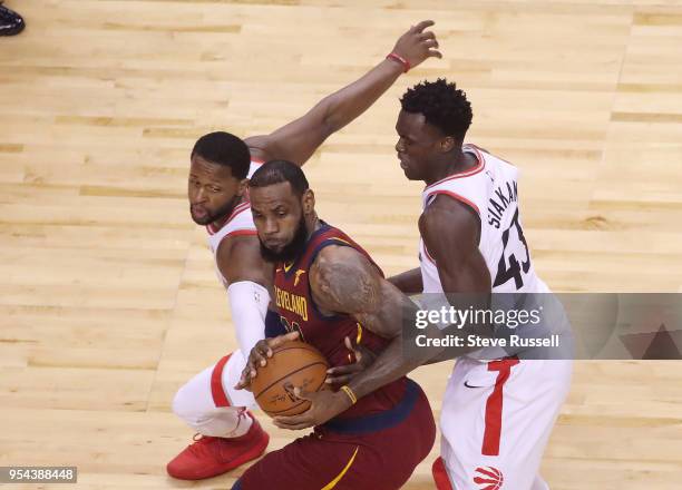 Toronto Raptors forward CJ Miles and \t32\ defend against Cleveland Cavaliers forward LeBron James as the Toronto Raptors lose game two 128-110 to...