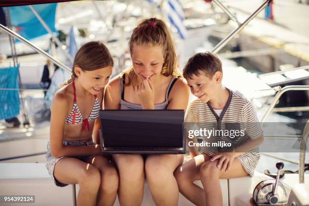 children using laptop on yacht - miljko stock pictures, royalty-free photos & images