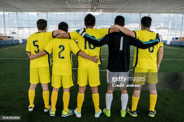 male soccer indoor players embracing ready to start the game - indoor soccer stock pictures, royalty-free photos & images