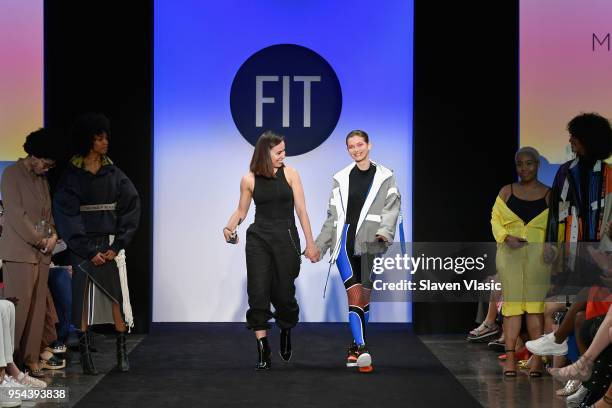 Critic Award winner Michelle Ortega walks the runway with a model during the 2018 Future Of Fashion Runway Show at The Fashion Institute of...