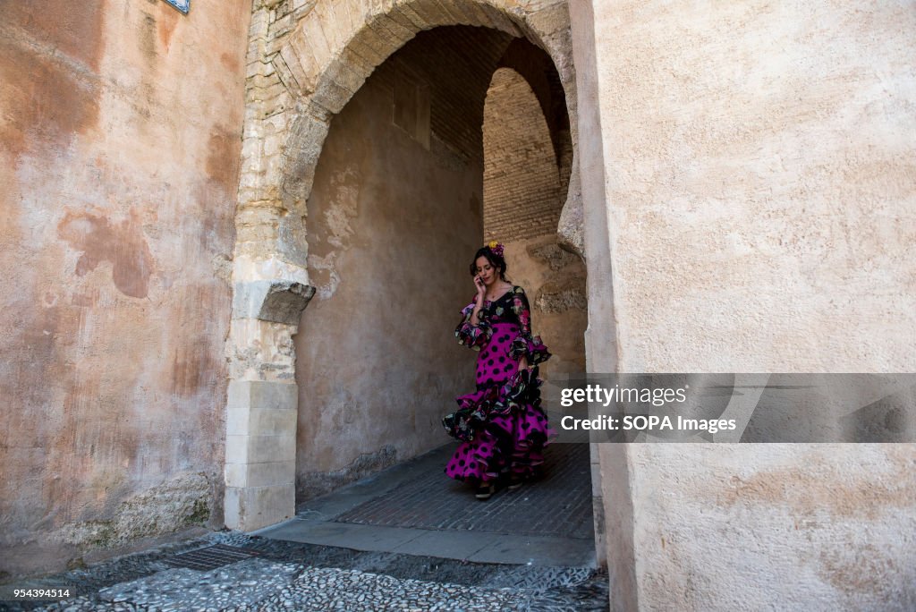 A girl wearing a typical flamenco dress walking throught the...