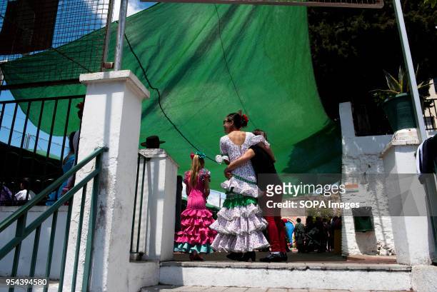 Women wearing a typical flamenco dress seen on the street of streets of Albaicin neighbourhood. El día de la Cruz or Día de las Cruces is one of the...