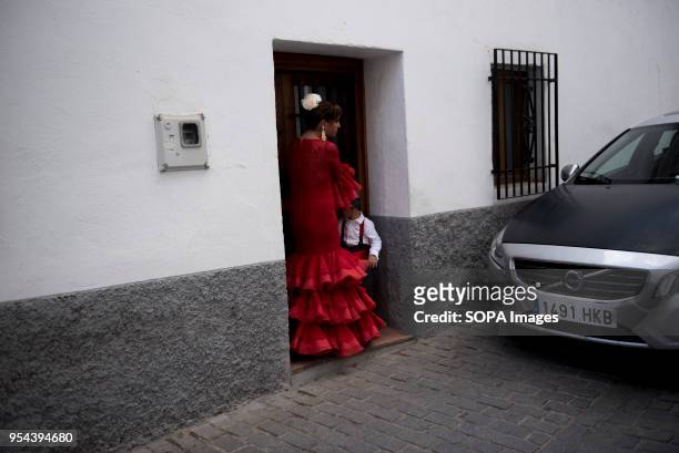 Woman with her son wearing a typical Flamenco dress seen in a street of Albaicin neighbourhood during the Dia de las Cruces in Granada.El día de la...