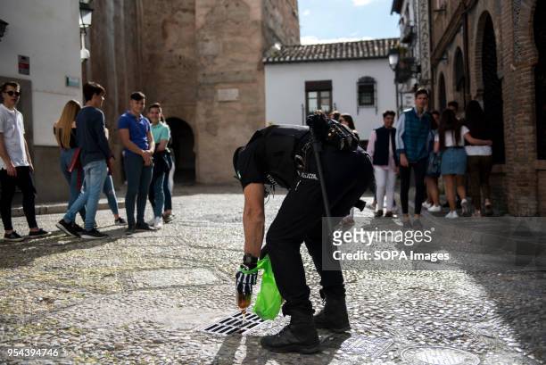 Policeman empties beer into a gutter. To drink alcohol was forbidden in Plaza Larga Square during El día de la Cruz or Día de las Cruces is one of...