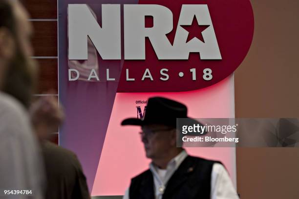 Attendees walk past signage inside the Kay Bailey Hutchison Convention Center ahead of the National Rifle Association annual meeting in Dallas,...