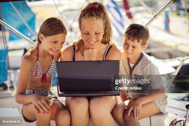 children using laptop on yacht - miljko stock pictures, royalty-free photos & images