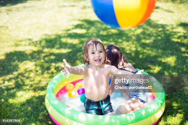 two children having fun in inflatable swimming pool - inflatable swimming pool stock pictures, royalty-free photos & images