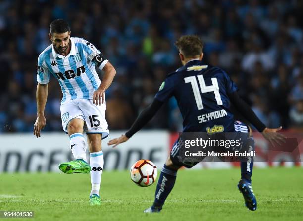 Lisandro Lopez of Racing Club kicks the ball against Felipe Seymour of Universidad de Chile during a group stage match between Racing Club and...