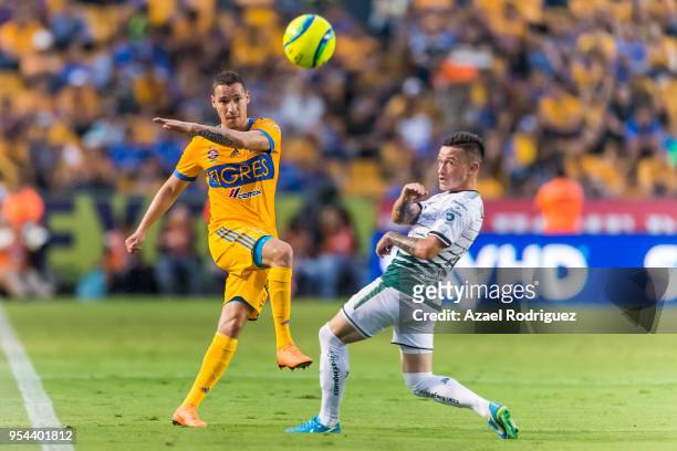 Jesus Duenas of Tigres fights kicks the ball past Brian Lozano of Santos during the quarter finals first leg match between Tigres UANL and Santos...