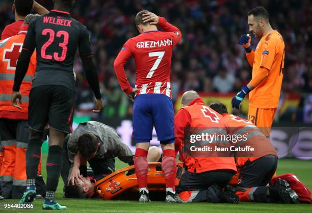 Antoine Griezmann of Atletico Madrid looks at his teammate in the French national team Laurent Koscielny of Arsenal, seriously injured during the...