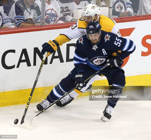 Mark Scheifele of the Winnipeg Jets works the puck past Nick Bonino of the Nashville Predators in Game Four of the Western Conference Second Round...