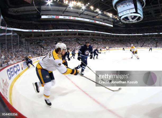Filip Forsberg of the Nashville Predators plays the puck around the corner boards as Adam Lowry of the Winnipeg Jets defends during first period...